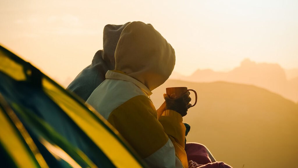 Couple enjoying a morning cup of coffee while watching the sun rise at a Music Festival.